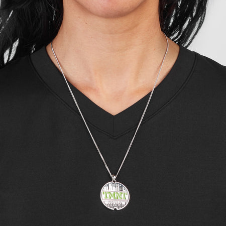 Close up of the engraved Ninjas in New York text on the TMNT Sewer Lid Necklace