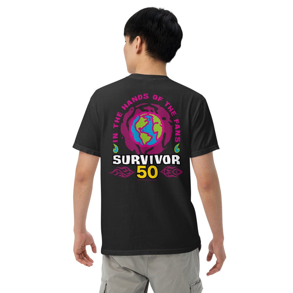 Back of a person wearing a black t-shirt with a colorful graphic: "IN THE HANDS OF THE FANS", abstract globe, "SURVIVOR 50".