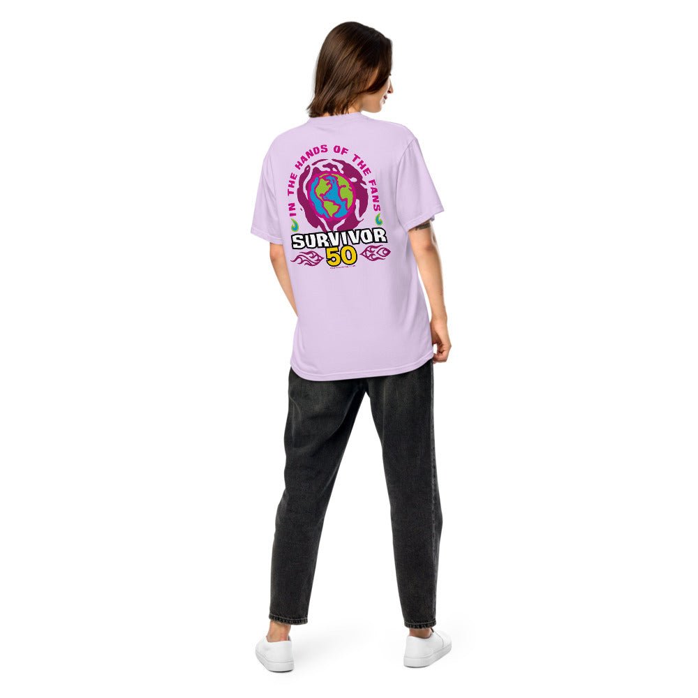 Back view of person in purple t-shirt with "IN THE HANDS OF THE FANS", a globe, and "SURVIVOR 50" graphic.